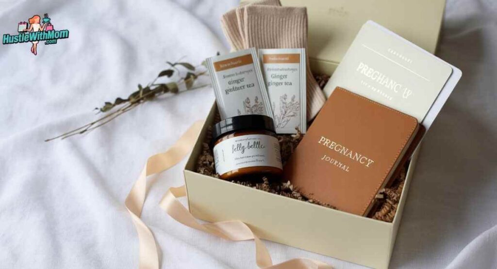 A beautifully styled flat lay of an open pregnancy gift box filled with belly butter, ginger tea, compression socks, and a pregnancy journal on a white linen surface.
